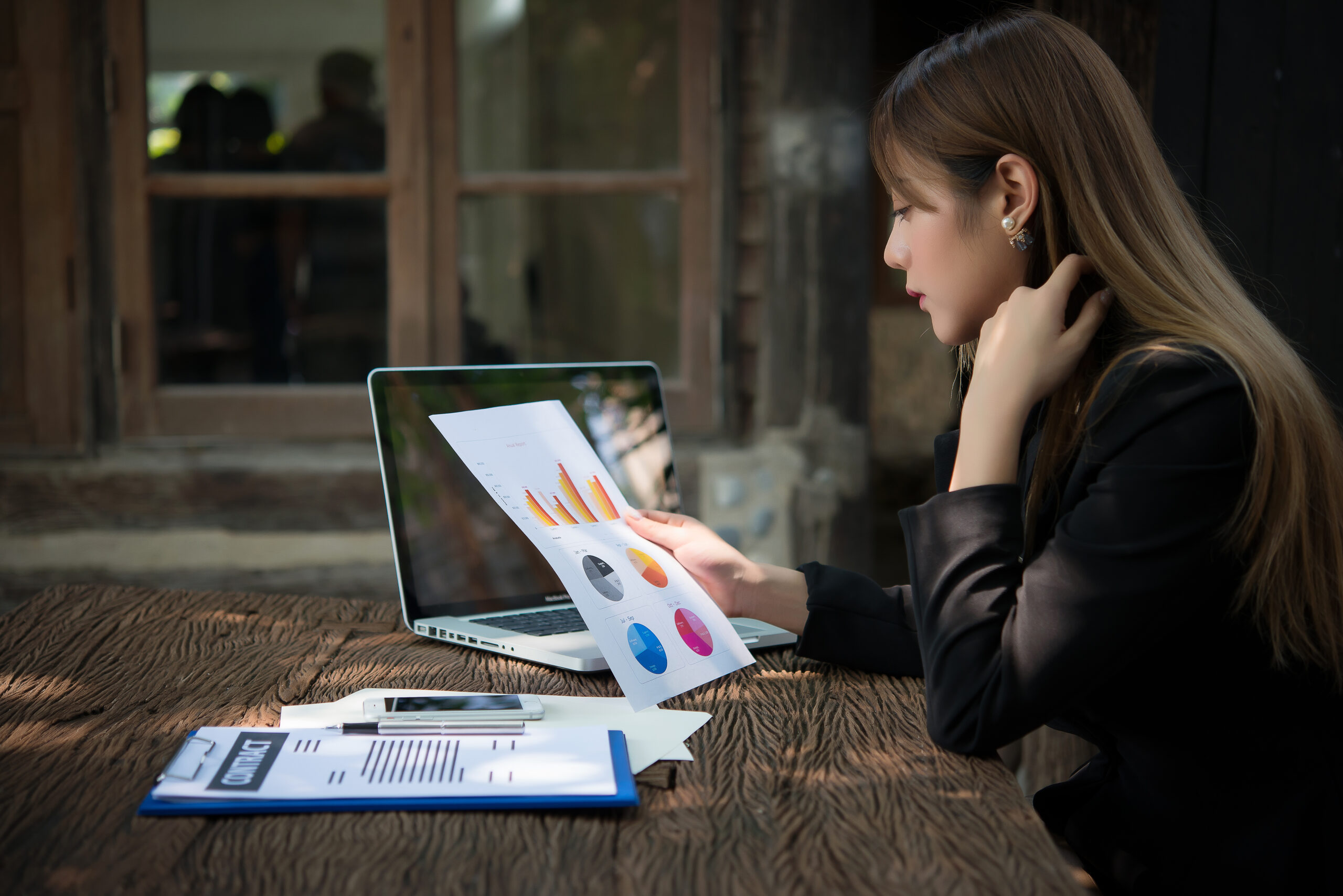 business woman working with documents graphs ,analyzing investment chart working in office.